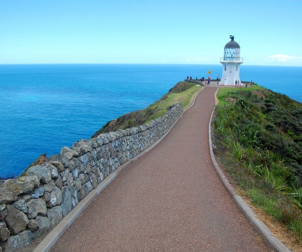 phare blanc au sommet d'une montagne surplombant l'océan bleu